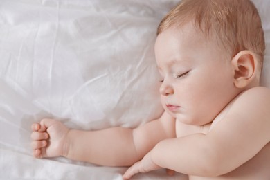 Photo of Cute little baby sleeping on bed at home, top view