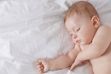 Cute little baby sleeping on bed at home, top view