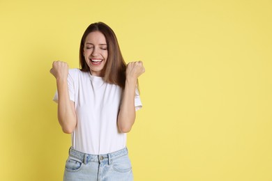 Photo of Happy winner on yellow background, space for text