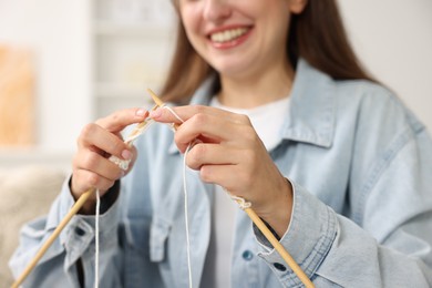 Photo of Woman knitting with needles at home, closeup