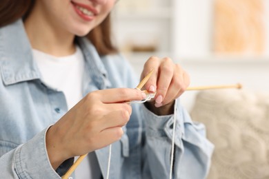 Woman knitting with needles at home, closeup