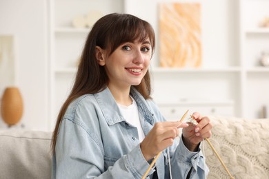 Beautiful woman knitting with needles at home