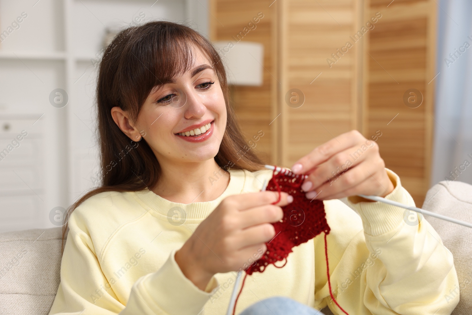 Photo of Beautiful woman knitting with needles at home