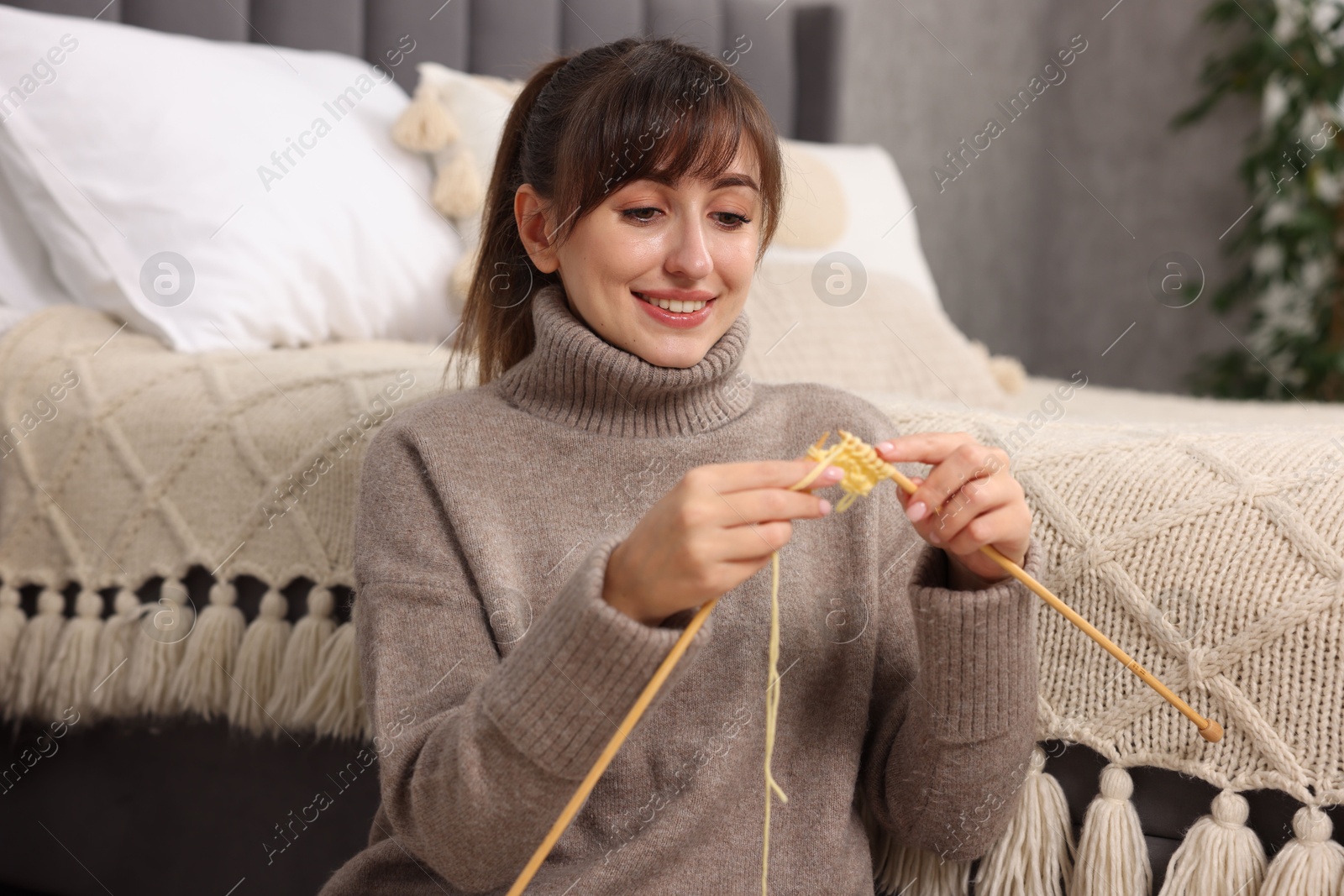 Photo of Beautiful woman knitting with needles at home