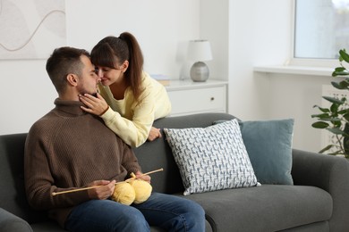 Photo of Woman teaching her boyfriend how to knit at home