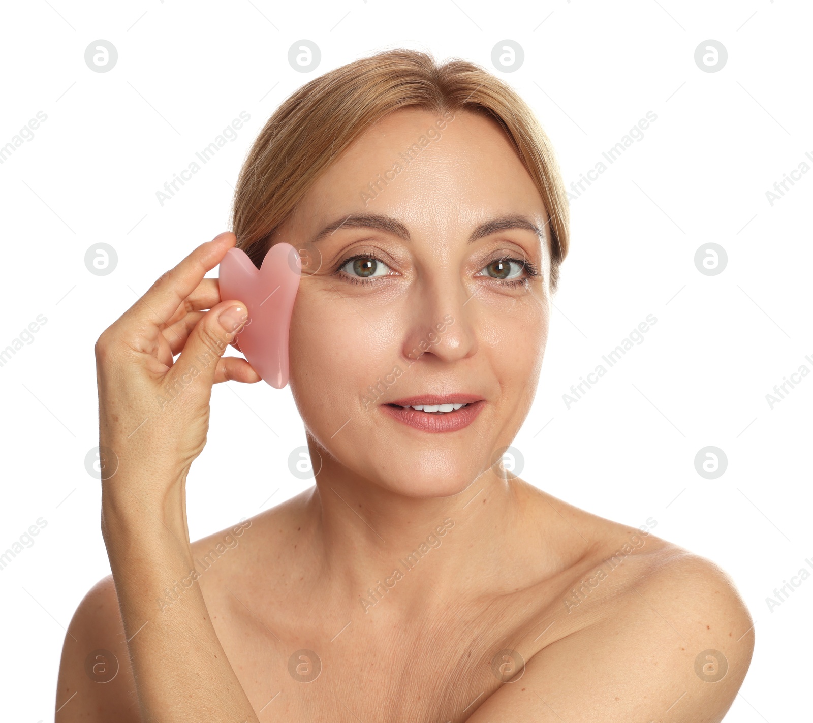 Photo of Smiling woman doing facial self massage with gua sha tool on white background