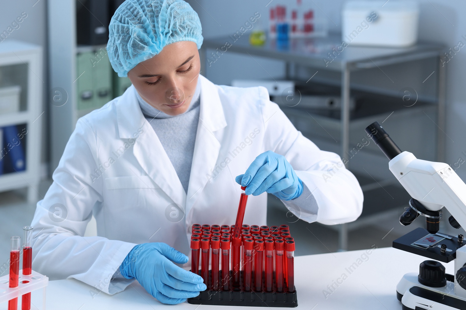 Photo of Laboratory testing. Doctor taking test tube with blood sample at table indoors