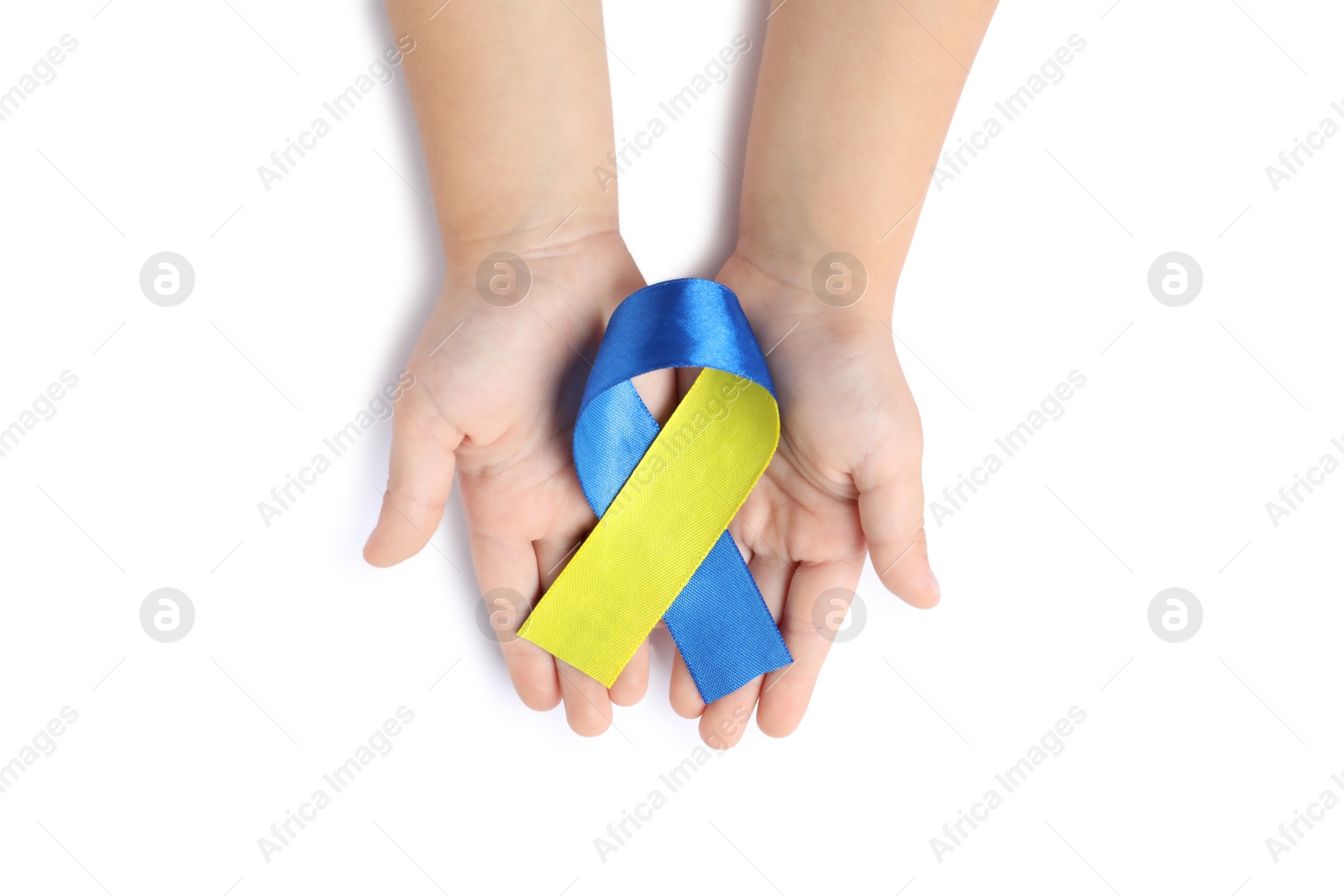 Photo of Child with yellow and blue ribbon on white background, top view. Down syndrome awareness