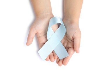 Photo of Child with light blue ribbon on white background, top view. Childhood cancer awareness