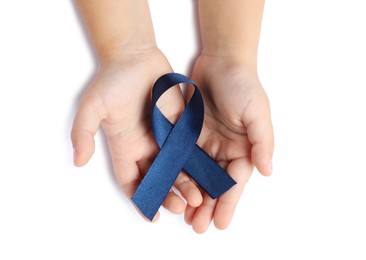 Photo of Child with dark blue ribbon on white background, top view. Arthritis disease and colon cancer awareness