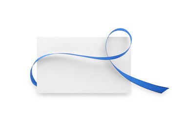 Photo of Blank card and blue ribbon isolated on white, top view