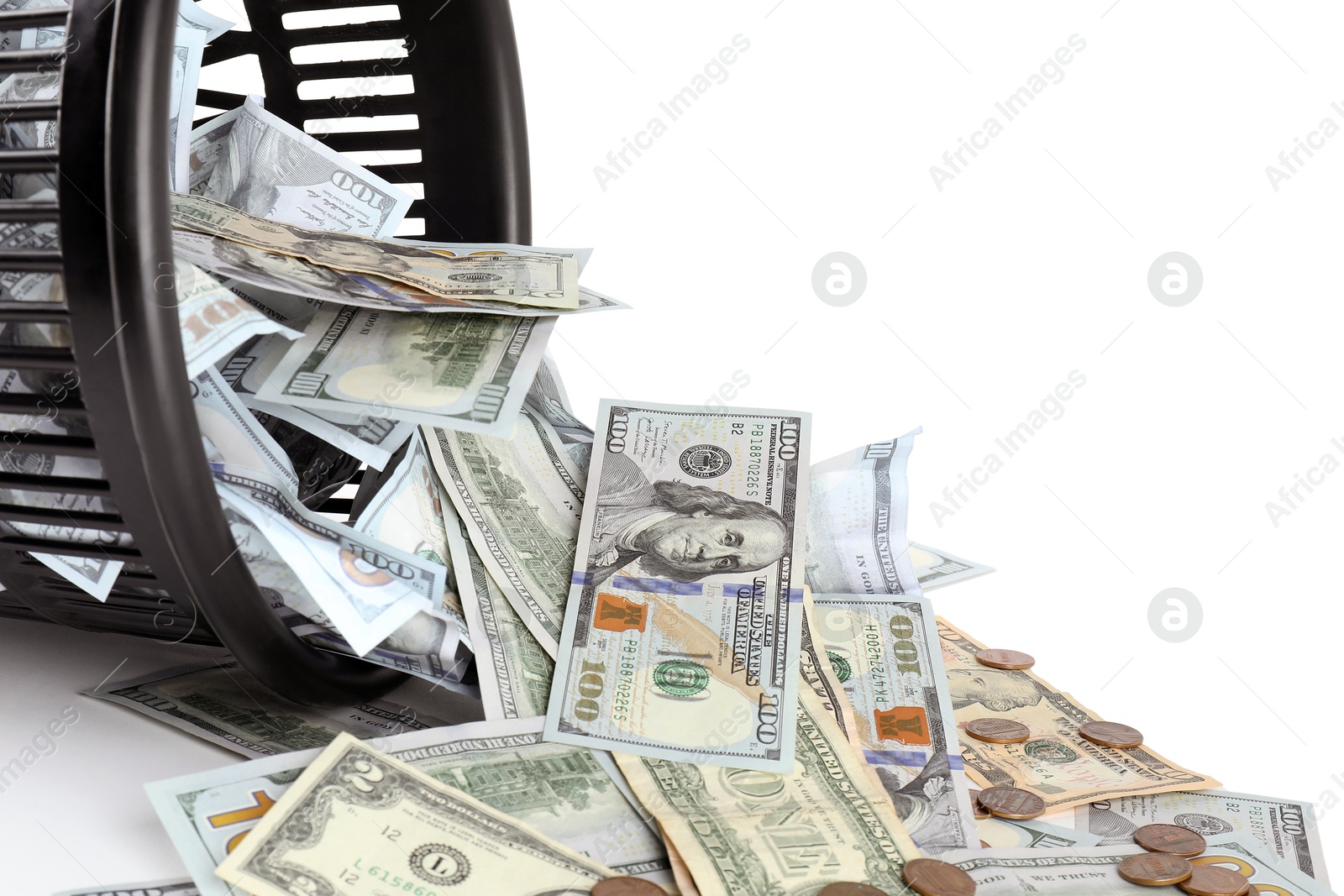 Photo of Many dollar banknotes, coins and overturned trash bin isolated on white