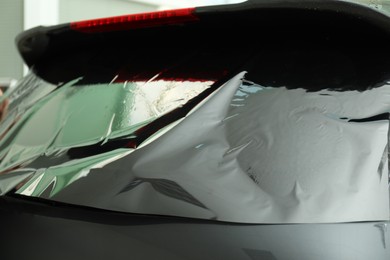 Car window covered with tinting foil, closeup