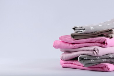 Photo of Stack of clean bed sheets on white background. Space for text