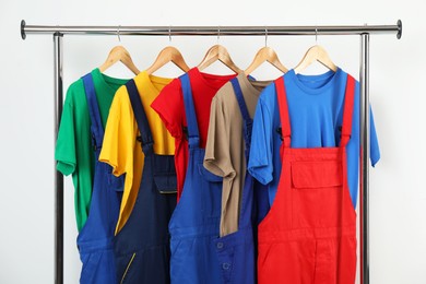 Photo of Workers' uniforms on clothing rack near grey wall indoors