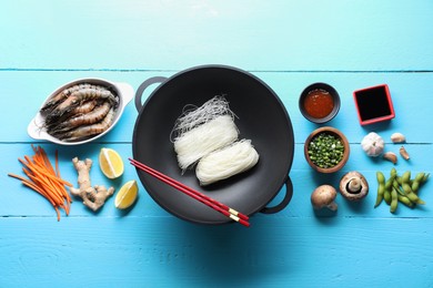 Photo of Different ingredients for wok on light blue wooden table, flat lay