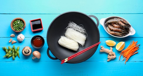 Photo of Different ingredients for wok on light blue wooden table, flat lay