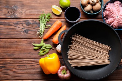 Different ingredients for wok on wooden table, flat lay