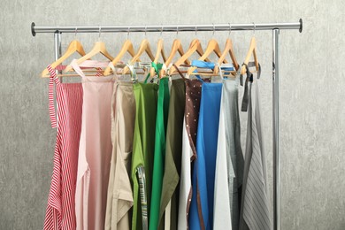 Photo of Aprons on clothing rack near light grey wall