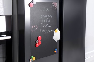 Photo of Magnetic board with shopping list and notes on refrigerator in kitchen