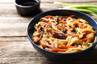 Photo of Stir-fry noodles with sea food and vegetables on wooden table, closeup