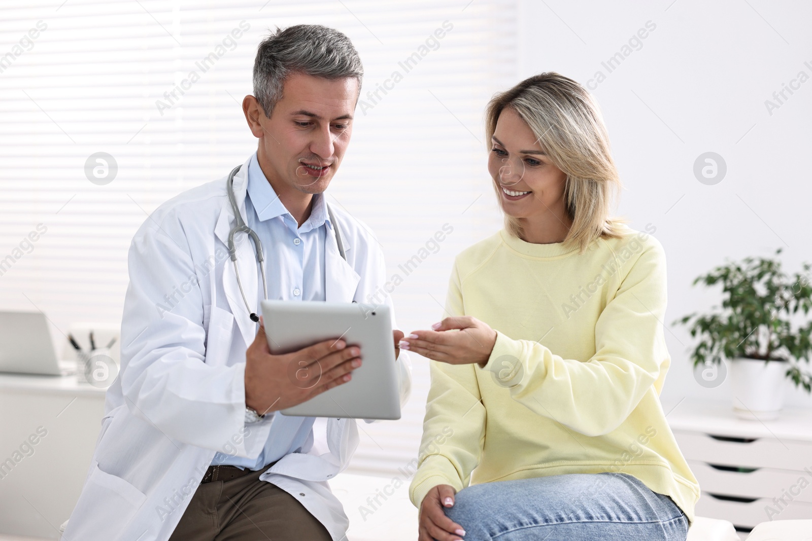 Photo of Healthcare worker with tablet and patient in hospital