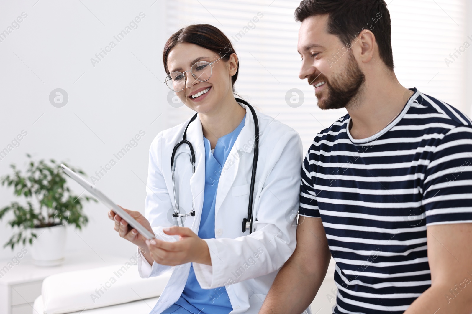 Photo of Healthcare worker with tablet and patient in hospital