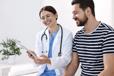 Healthcare worker with tablet and patient in hospital