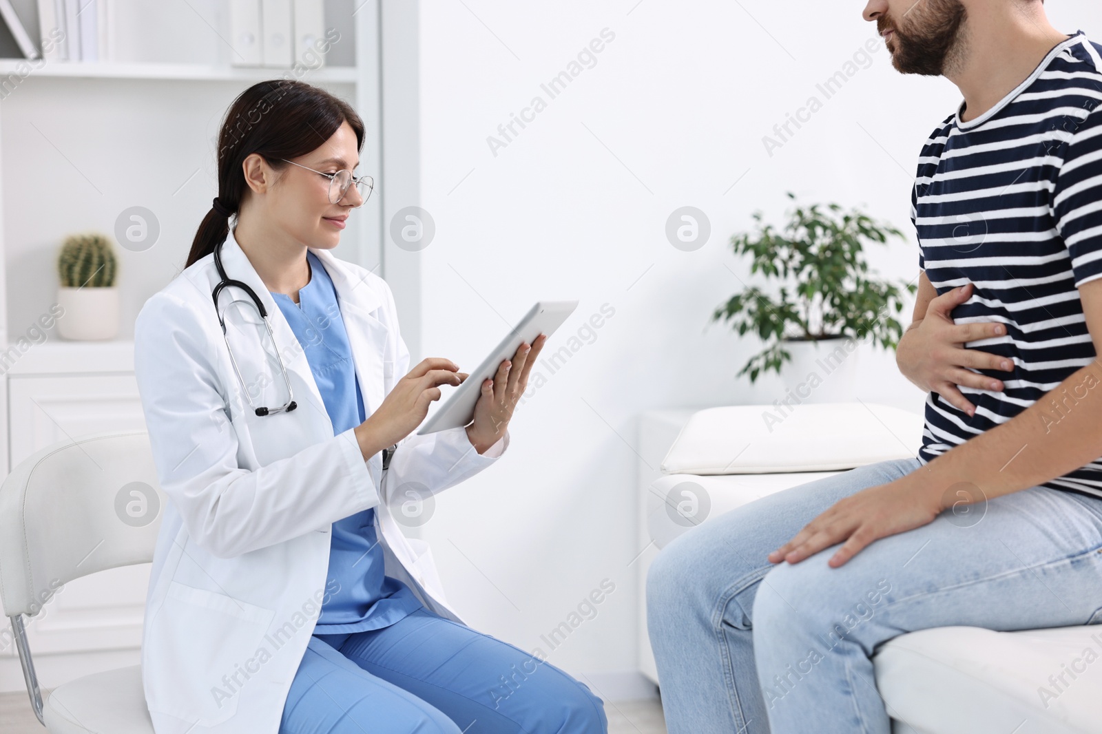 Photo of Healthcare worker with tablet and patient in hospital