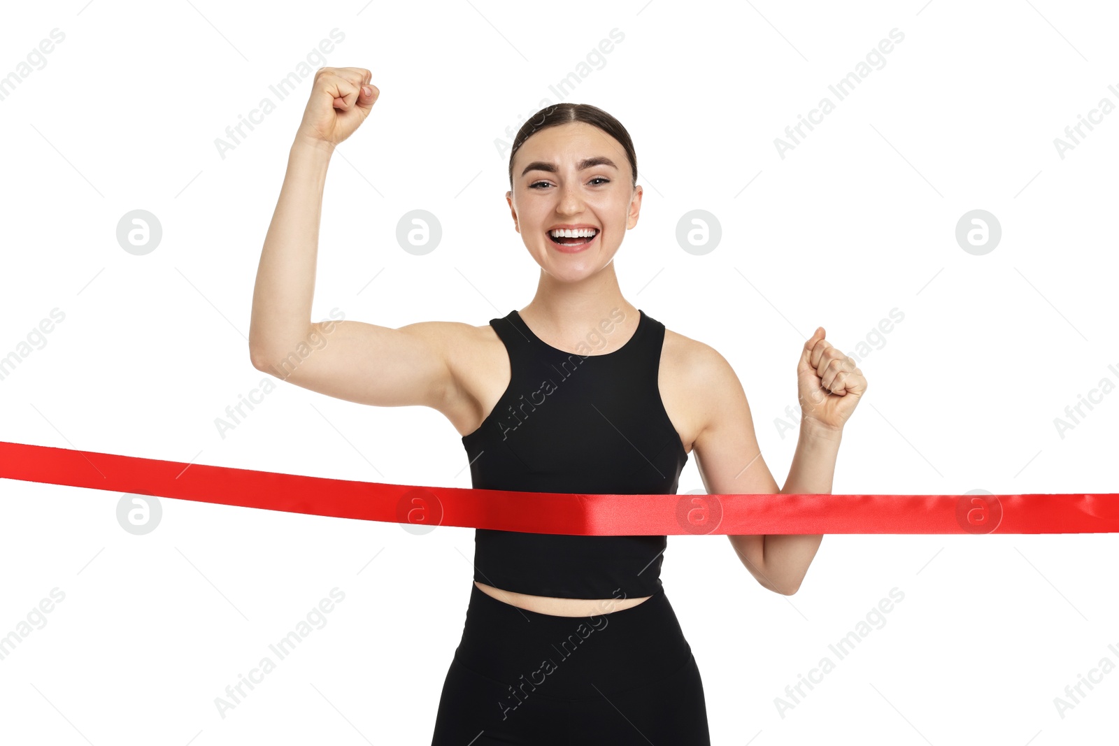 Photo of Beautiful woman in sportswear crossing red finish line on white background