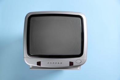 Photo of Retro tv set on light blue background, top view