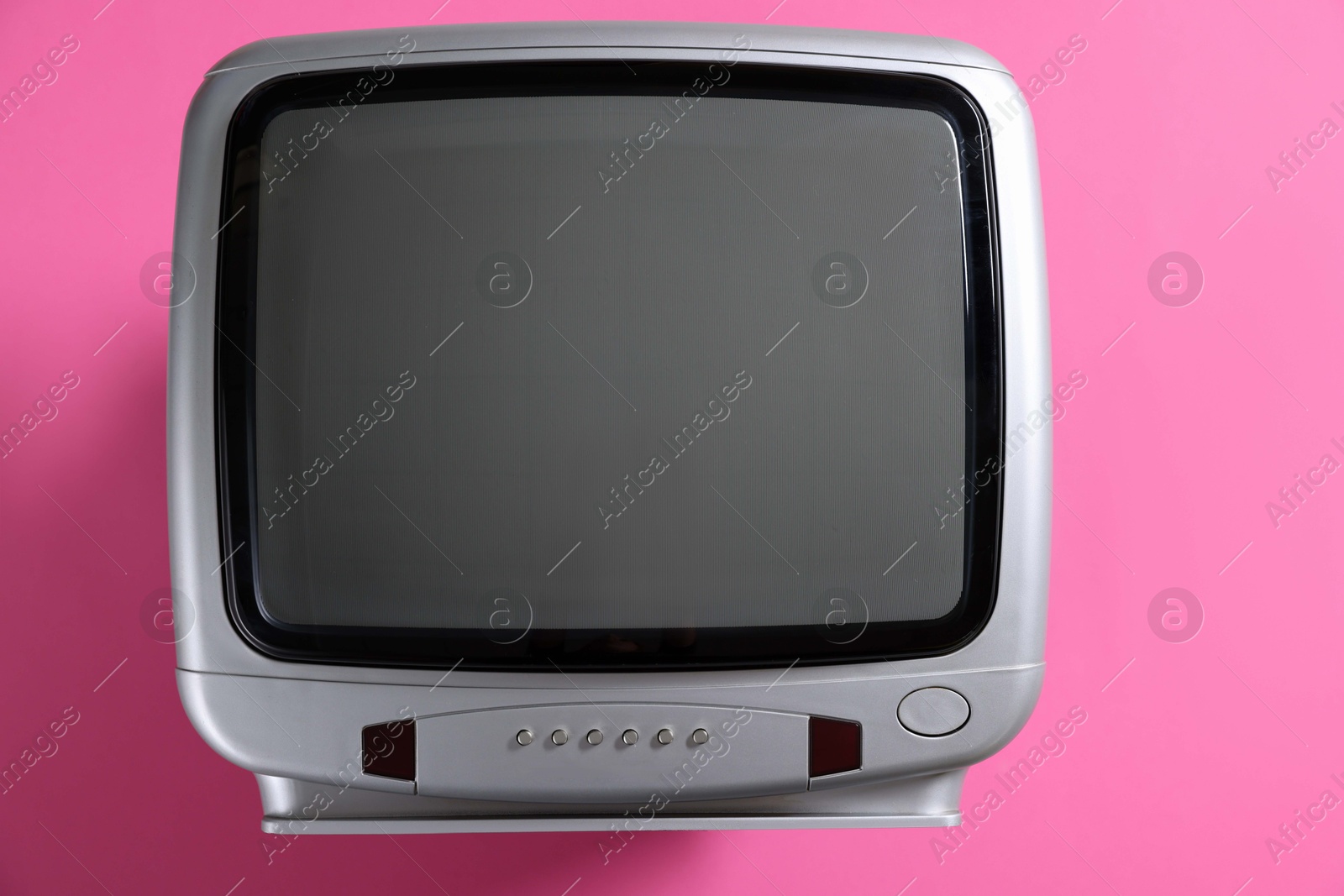 Photo of Retro tv set on pink background, top view