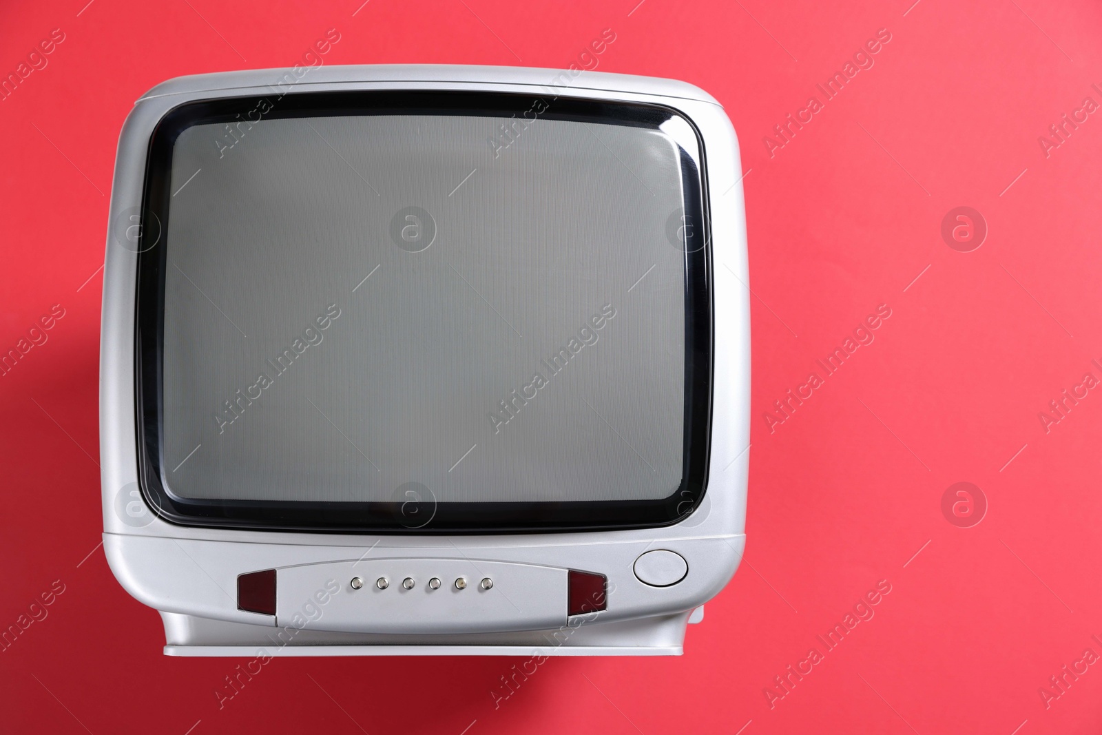 Photo of Retro tv set on red background, top view