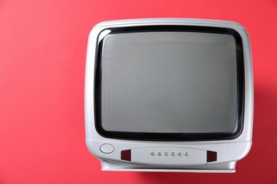 Photo of Retro tv set on red background, top view