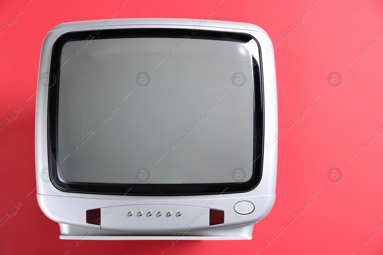 Photo of Retro tv set on red background, top view