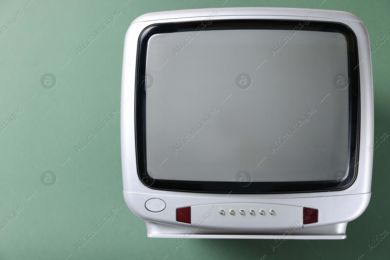 Photo of Retro tv set on green background, top view. Space for text