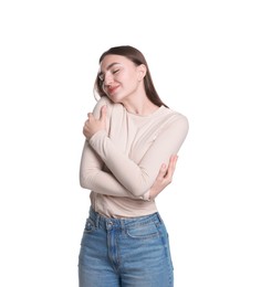 Photo of Charming young woman hugging herself on white background