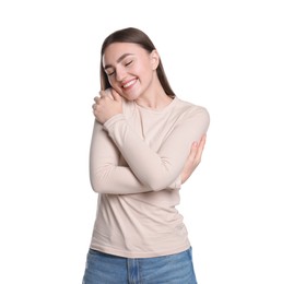 Charming young woman hugging herself on white background