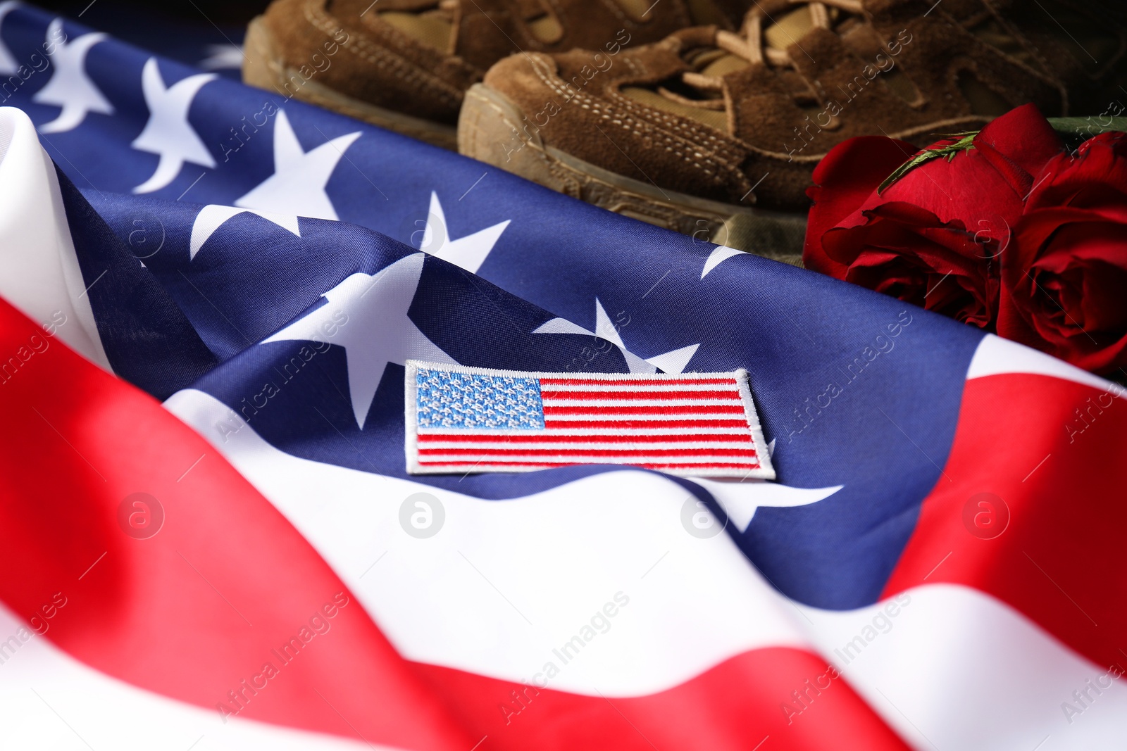 Photo of Veterans day. USA army patch, American flag, roses and military shoes, closeup