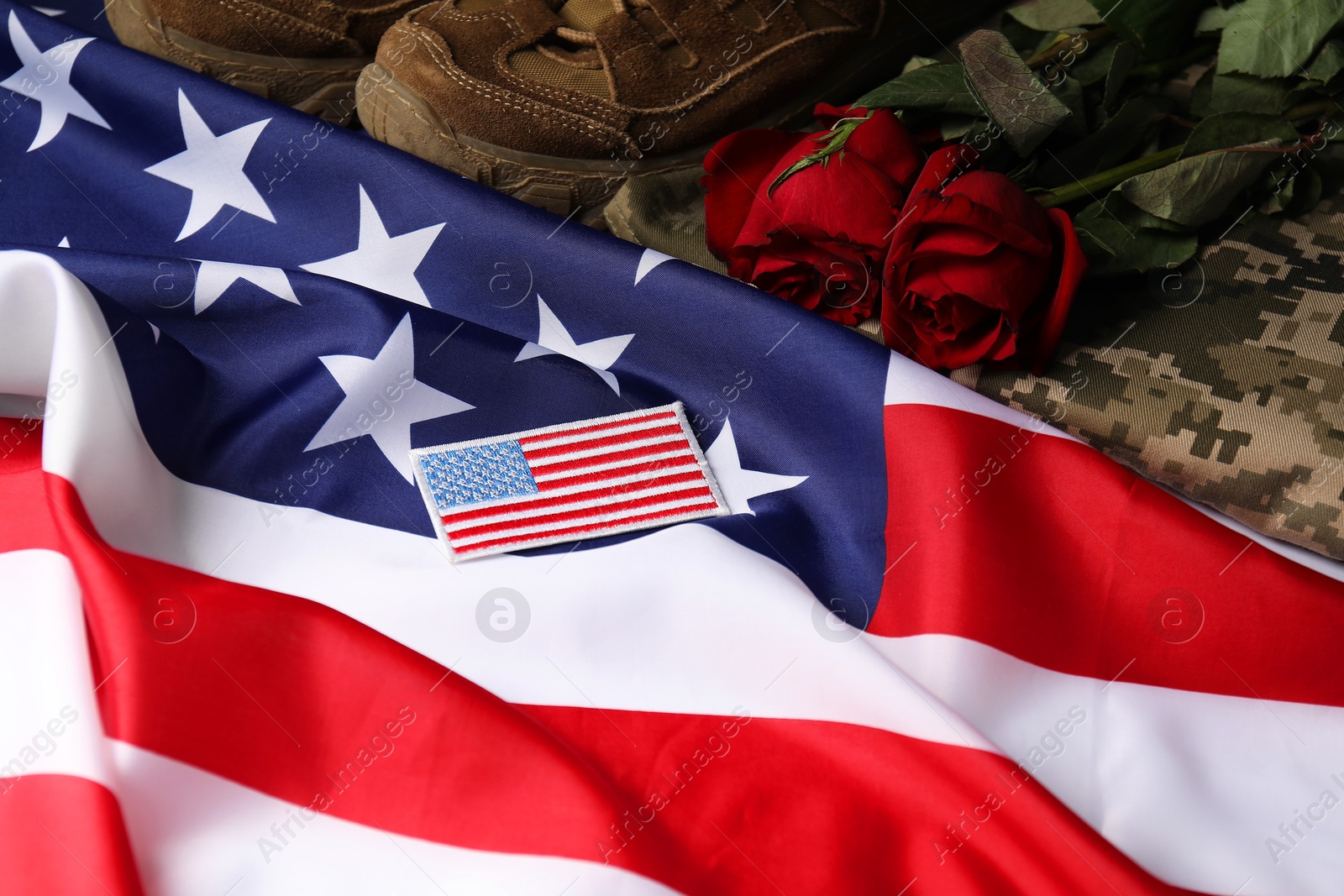 Photo of Veterans day. USA army patch, American flag, roses and military uniform, above view