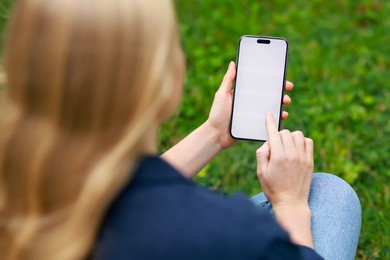 Photo of Woman using smartphone on green grass outdoors