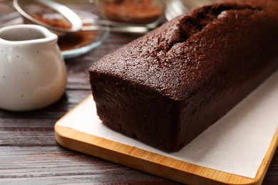 Photo of Tasty chocolate sponge cake on wooden table, closeup