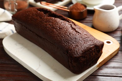 Photo of Tasty chocolate sponge cake on wooden table, closeup