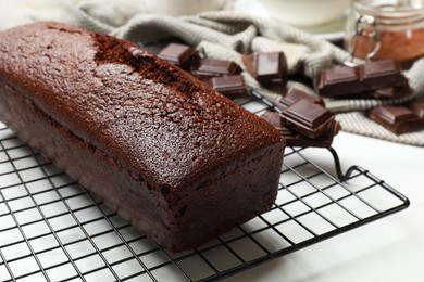 Photo of Tasty chocolate sponge cake on white table, closeup