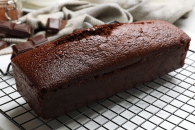 Photo of Tasty chocolate sponge cake on white table, closeup