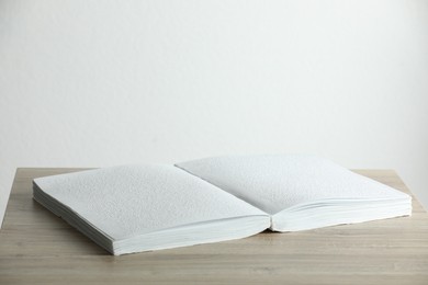 Photo of Book with Braille text on wooden table. Education and leisure for blind people