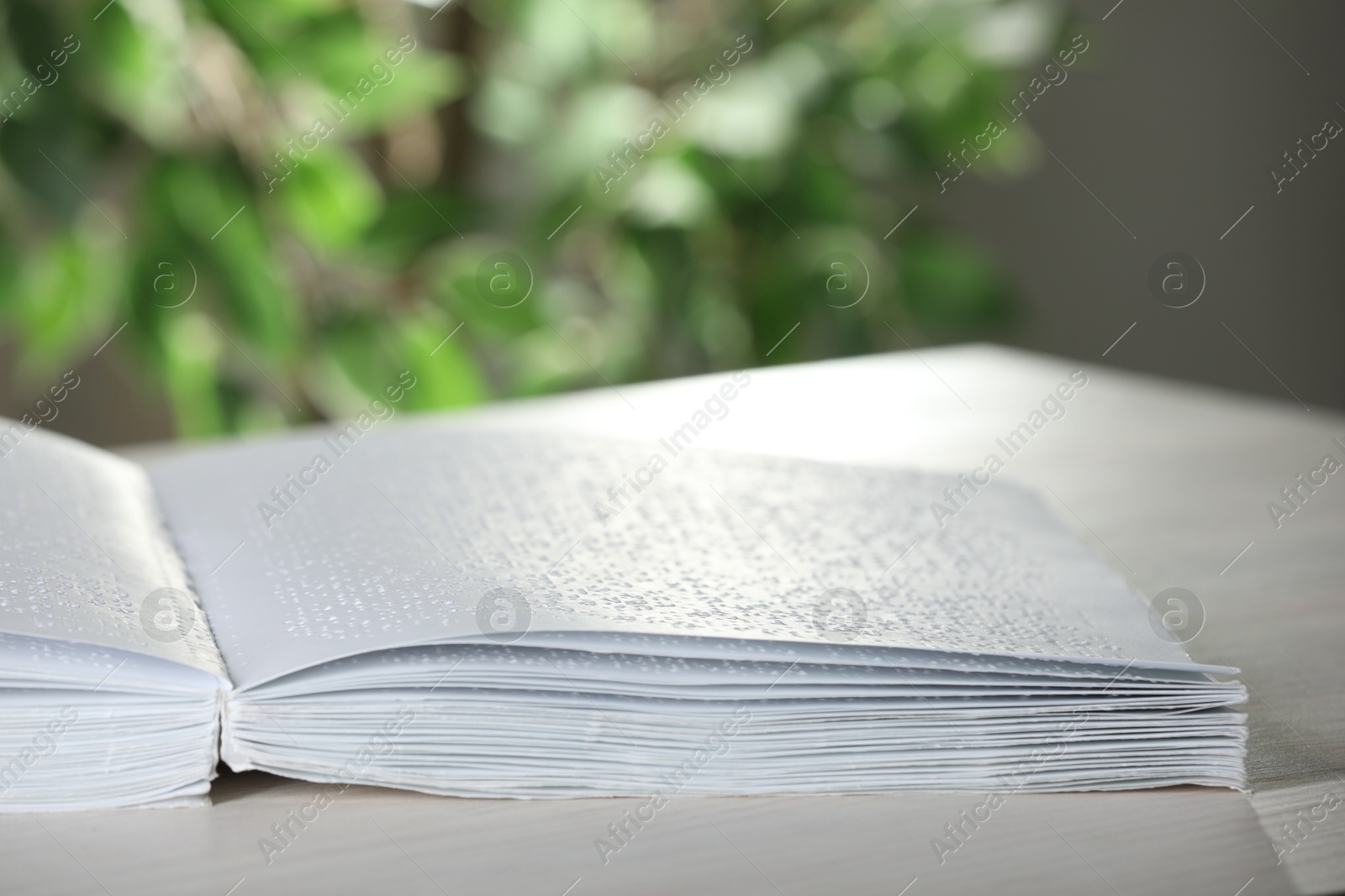 Photo of Book with Braille text on table, closeup. Education and leisure for blind people