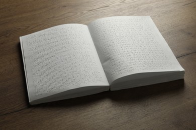 Photo of Book with Braille text on wooden table. Education and leisure for blind people