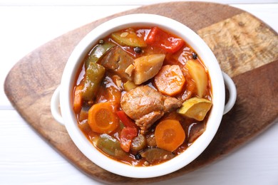 Photo of Delicious stew with vegetables in bowl on white table, top view