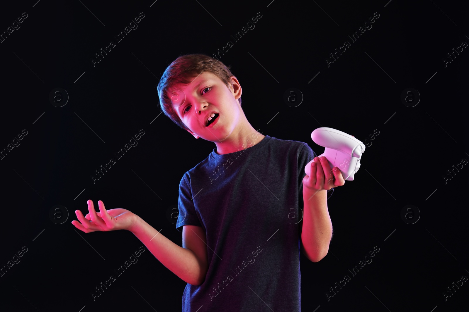 Photo of Cute little boy with controller on black background